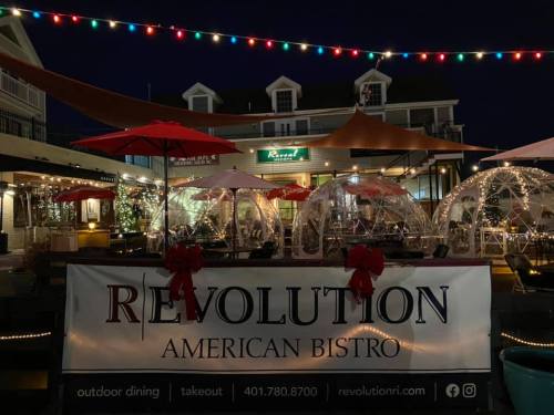 Outdoor dining area at Revolution American Bistro, decorated with festive lights and holiday decor.