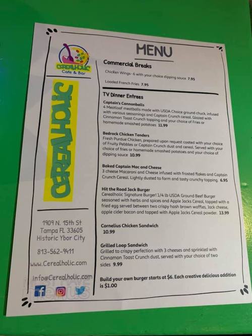 Menu from Cerealholic Cafe featuring chicken wings, tenders, sandwiches, and various entrees with prices listed.