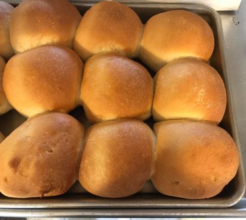 Freshly baked golden brown dinner rolls arranged in a tray.