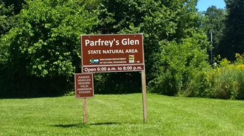 Sign for Parfrey's Glen State Natural Area, open 6:00 a.m. to 8:00 p.m., with parking sticker information.