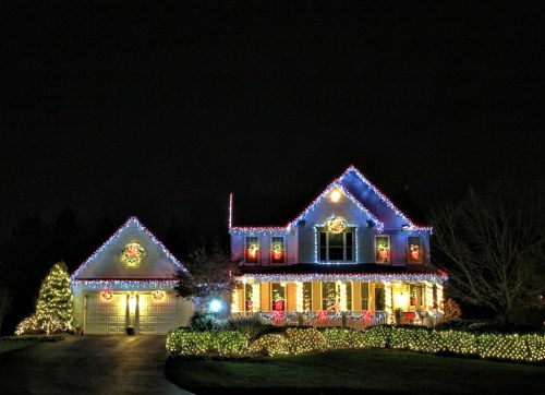 A beautifully decorated house at night, adorned with colorful Christmas lights and festive wreaths.