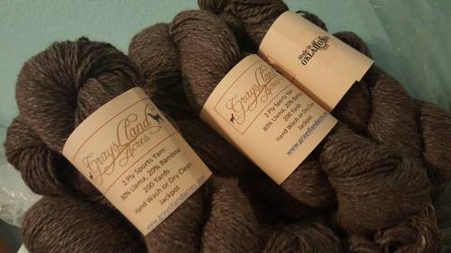 Three skeins of brown yarn with labels from Grayland Yarns, showcasing details about the yarn type and care instructions.