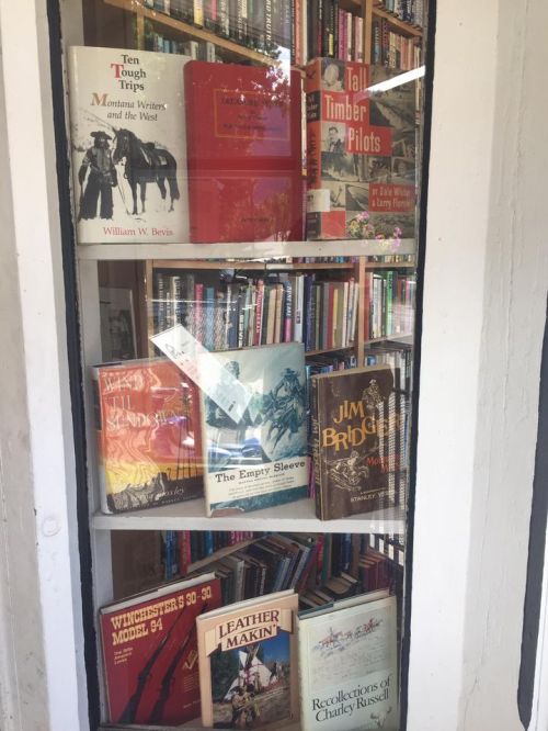 A display window filled with various books, showcasing titles on Montana writers and history.