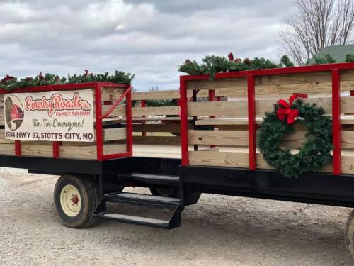 A festive wagon decorated with wreaths and garlands, parked at a family fun farm in Stotts City, MO.