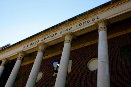 Exterior view of E.E. Bass Junior High School, featuring tall columns and a brick facade against a clear blue sky.