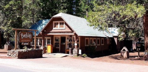 A rustic restaurant building surrounded by trees, featuring a sign that reads "Becky's Restaurant" and an open sign.