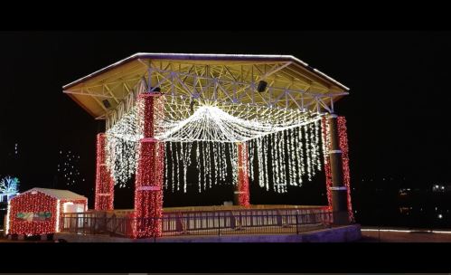 A beautifully lit gazebo adorned with cascading lights, set against a dark night sky.