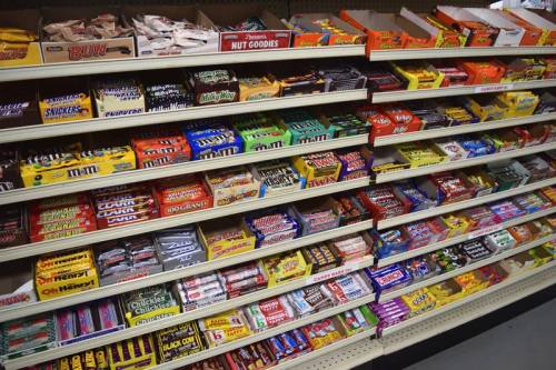 A colorful display of various candy bars and snacks arranged on shelves in a store.