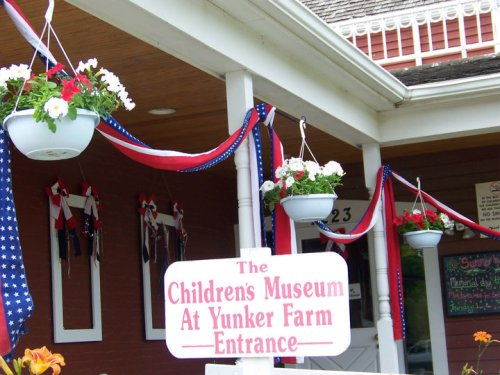 Entrance to the Children's Museum at Yunker Farm, decorated with flowers and red, white, and blue ribbons.