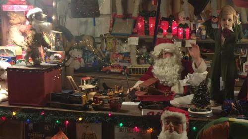 A festive display featuring Santa, vintage toys, and holiday decorations in a cozy, nostalgic setting.