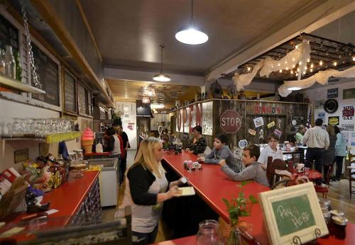 A cozy diner with a red counter, vintage decor, and patrons enjoying their meals in a warm, inviting atmosphere.