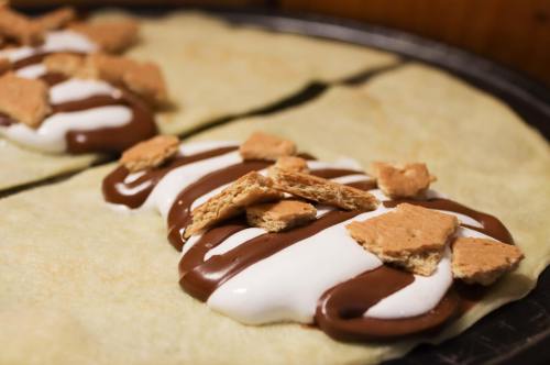 Two crepes filled with chocolate and marshmallow, topped with crushed graham crackers.