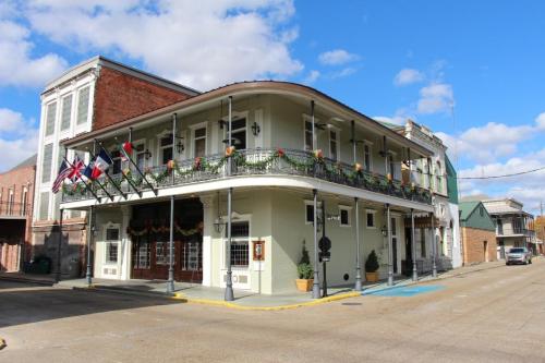Historic building with a curved balcony, adorned with flags, set against a blue sky with scattered clouds.