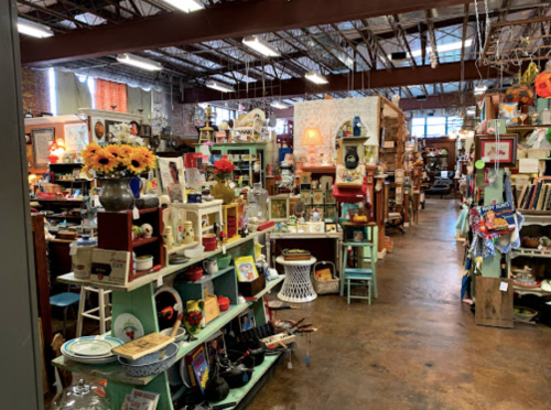 A vibrant antique shop filled with colorful decor, vintage items, and eclectic furnishings in a spacious interior.