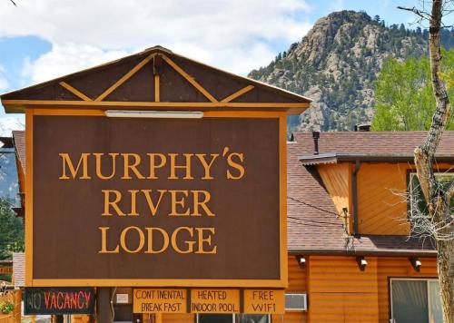 Sign for Murphy's River Lodge with mountains in the background, featuring amenities like free WiFi and an indoor pool.