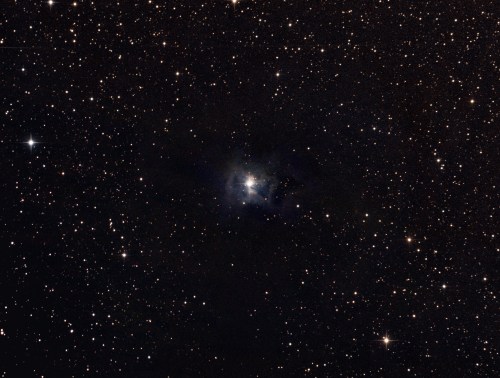 A starry night sky filled with countless stars, featuring a bright nebula at the center surrounded by dark space.