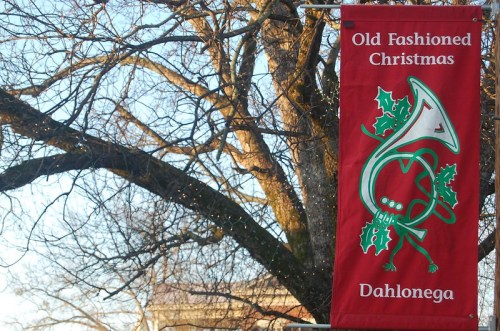 A red banner reading "Old Fashioned Christmas" with a musical horn and holly, hanging from a tree.
