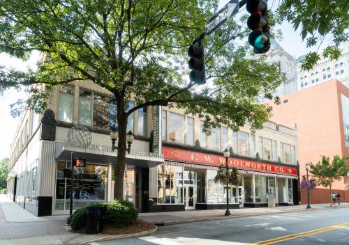 Historic building with a red awning reading "F.W. Woolworth Co." and a tree in front, on a city street.