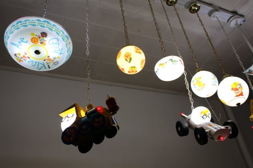 Colorful hanging lights in various shapes, including a train and airplane, create a playful atmosphere.