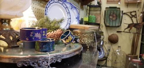 A display of vintage items, including decorative rings, a pinecone, and various antique objects on a table.