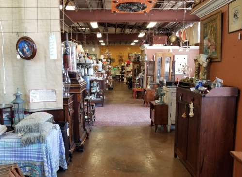 A spacious antique shop filled with various vintage furniture and decor items, creating a nostalgic atmosphere.