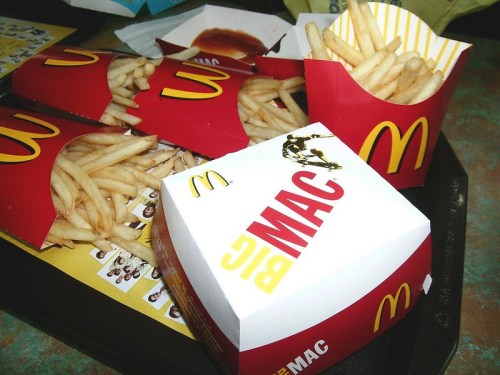 A tray with McDonald's fries and a Big Mac box, featuring the iconic red and yellow packaging.