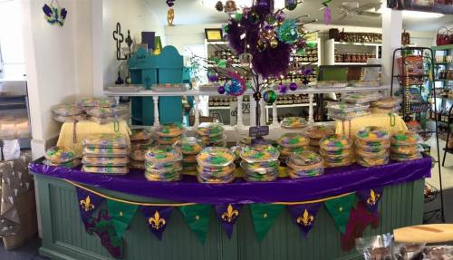 A colorful display of festive treats arranged in trays, decorated with purple and green, celebrating a festive occasion.