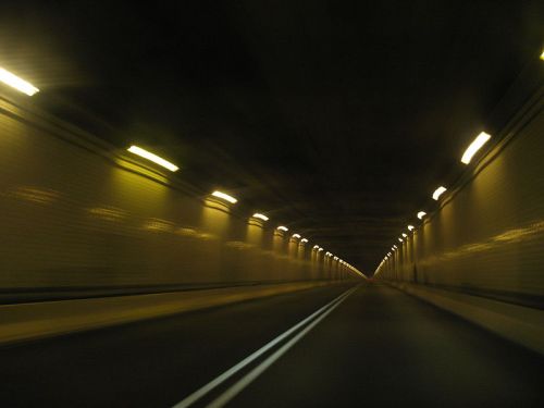 A dimly lit tunnel with lights along the walls, creating a sense of depth and motion.