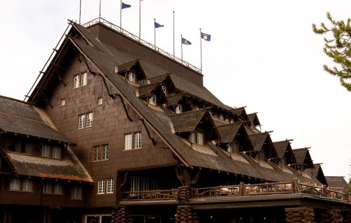 Historic lodge with a steeply pitched roof, wooden exterior, and multiple flags flying above.