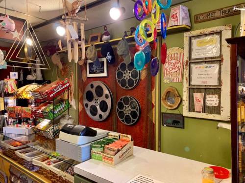 A vintage shop interior featuring film reels, colorful decor, and a display of snacks and popcorn.