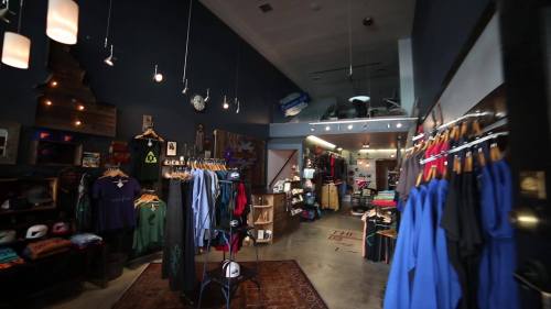 Interior of a trendy retail store featuring clothing racks, shelves, and stylish decor in a cozy atmosphere.