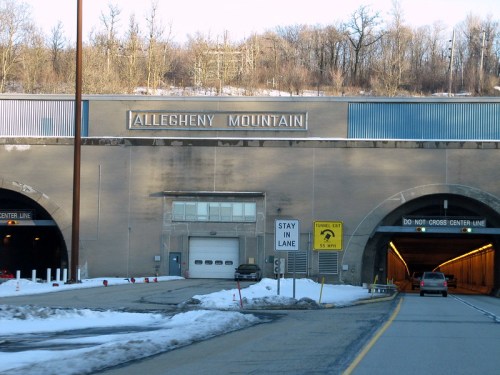 Entrance to the Allegheny Mountain tunnel, with snowy surroundings and a warning sign about lane usage.