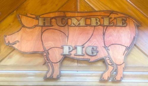 Wooden sign featuring a pig silhouette with the words "HUMBLE PIG" carved into it.