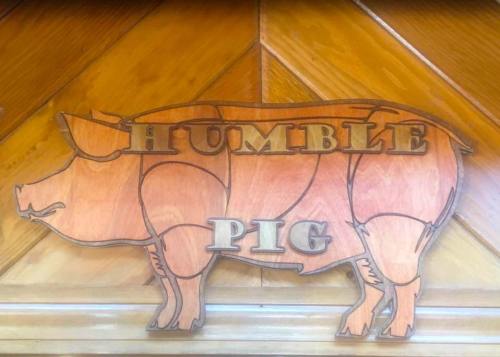 Wooden sign featuring a pig silhouette with the words "HUMBLE PIG" carved in bold letters.