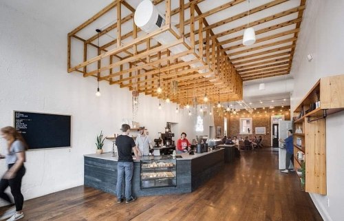 A modern coffee shop interior with wooden accents, a counter, and customers enjoying the space. Bright and inviting atmosphere.
