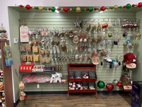 A festive display of Christmas ornaments and decorations on a wall, featuring various shapes and colors.