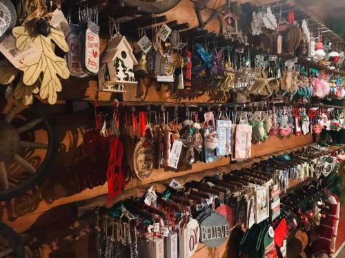 A wooden wall filled with various colorful ornaments, decorations, and crafts for the holiday season.