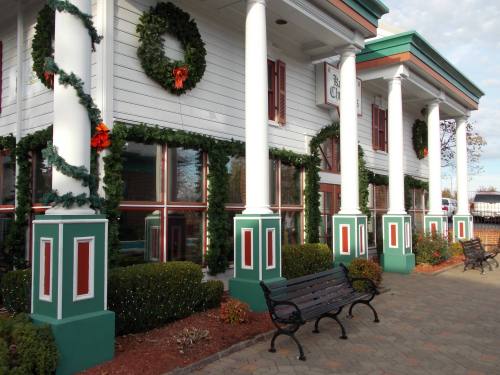A festive building decorated with wreaths and garlands, featuring green and red accents, and benches in front.