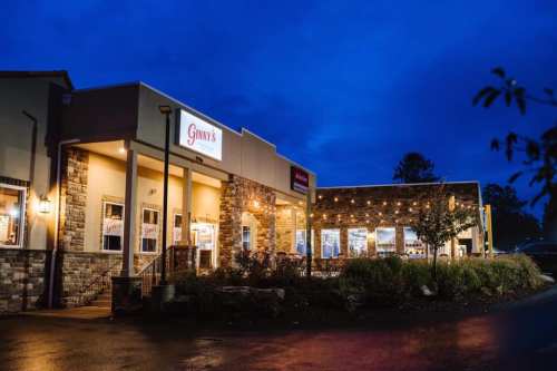 Exterior of Gunny's restaurant at dusk, featuring stone accents and warm lighting.