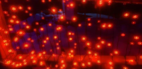 A close-up of glowing red lights arranged in a pattern against a dark background.