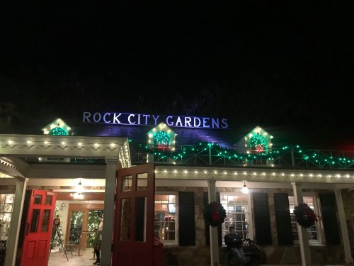 The entrance of Rock City Gardens, illuminated with festive lights and decorations at night.