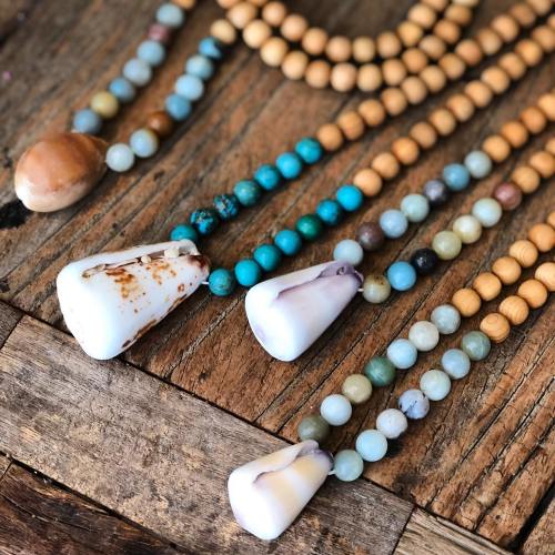 Colorful beads and shells arranged on a wooden surface, showcasing a variety of textures and shapes.