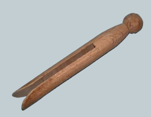 A wooden clothespin with a rounded top and a slotted grip, resting on a light blue background.
