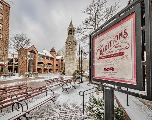 Snow-covered plaza featuring a clock tower and a sign for "Traditions" in a charming, wintery setting.