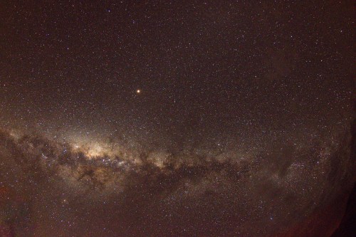 A stunning view of the night sky filled with stars and the Milky Way galaxy, showcasing a vast cosmic landscape.