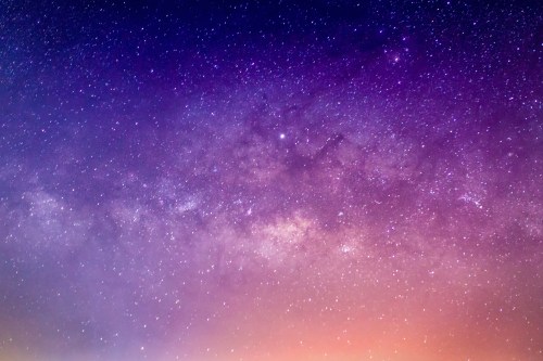 A stunning night sky filled with stars, showcasing a vibrant gradient from purple to orange.
