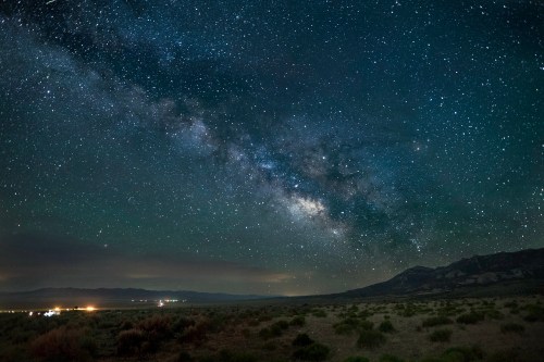 A stunning night sky filled with stars and the Milky Way over a dark, open landscape.