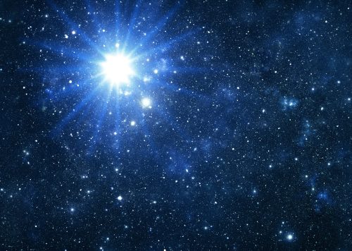 A bright star shines in a dark, star-filled galaxy, surrounded by twinkling celestial bodies.