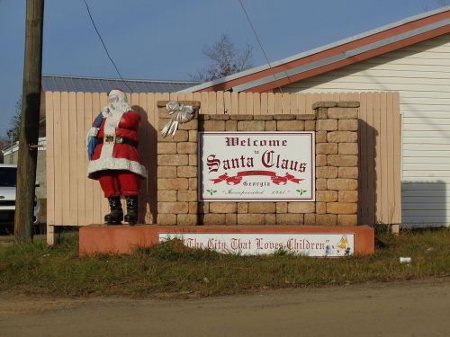 Welcome sign for Santa Claus, Georgia, featuring a Santa statue and festive decorations.
