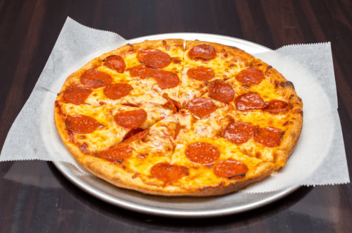 A freshly baked pepperoni pizza on a silver platter, with melted cheese and crispy crust.